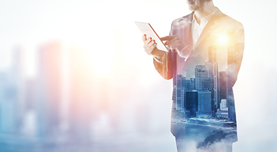 double exposure of city and business man using digital tablet