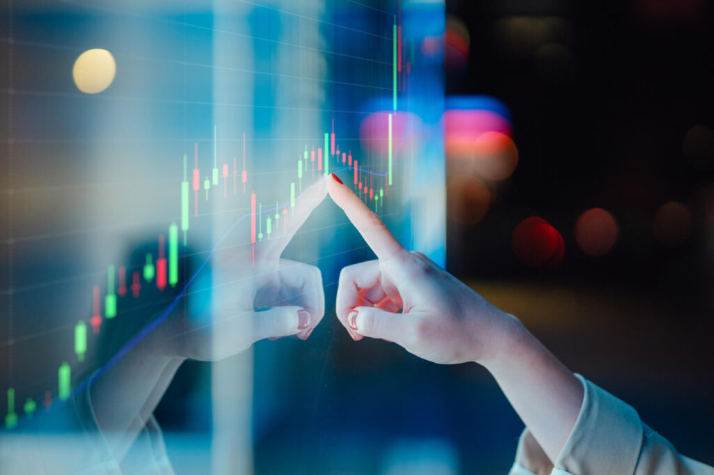 Businesswomen touching stock market graph on a virtual screen display