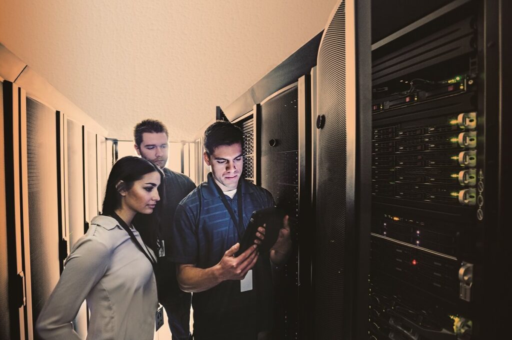 Technicians using digital tablet in server room