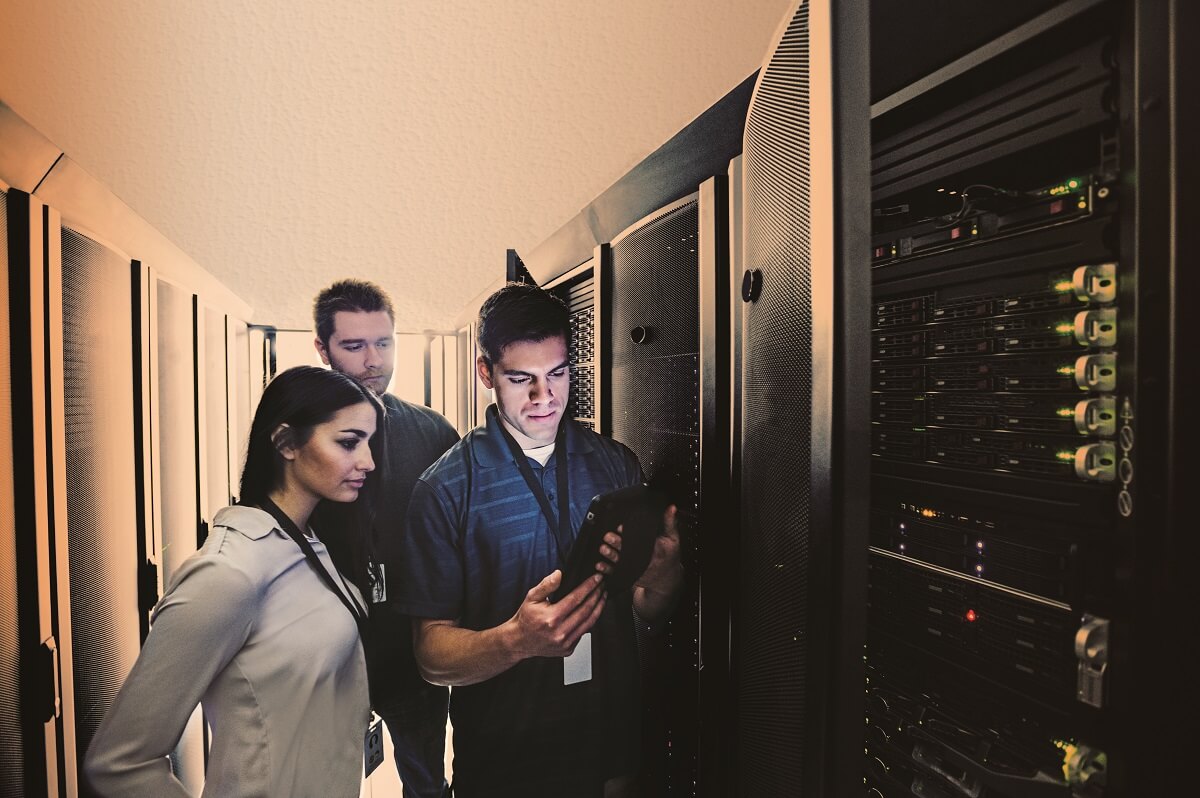 Technicians using digital tablet in server room